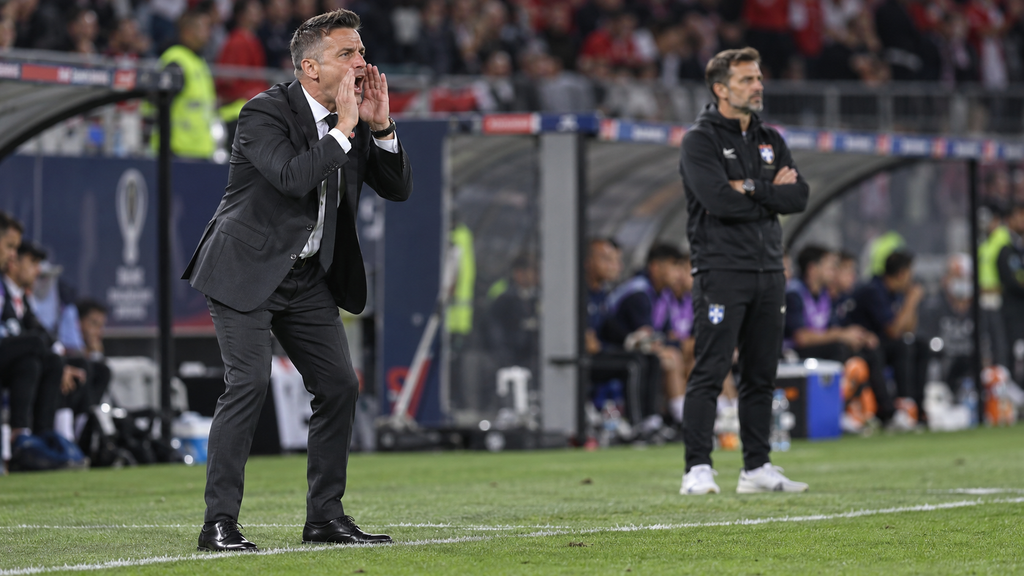 Komparasi visual pelatih John Herdman dan Anthony Hudson mengarahkan pemain dari area teknis tepi lapangan pertandingan.